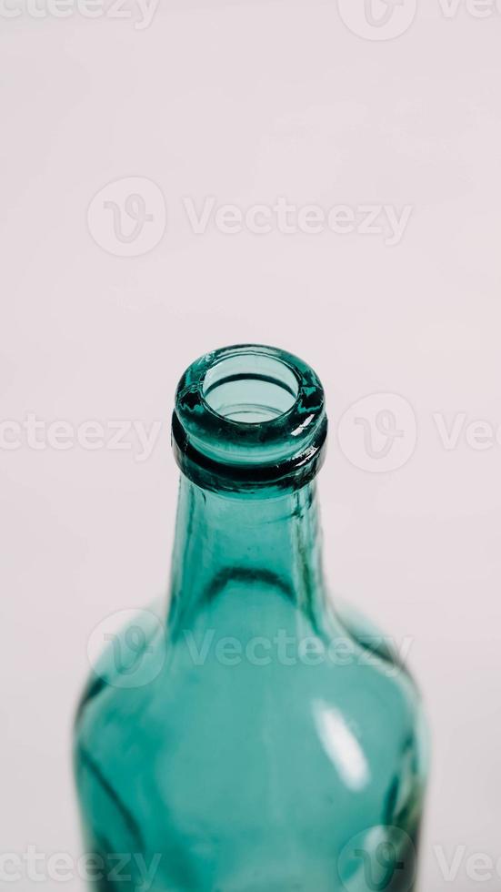 Glass transparent green bottle for liquids without the cap on a white background photo