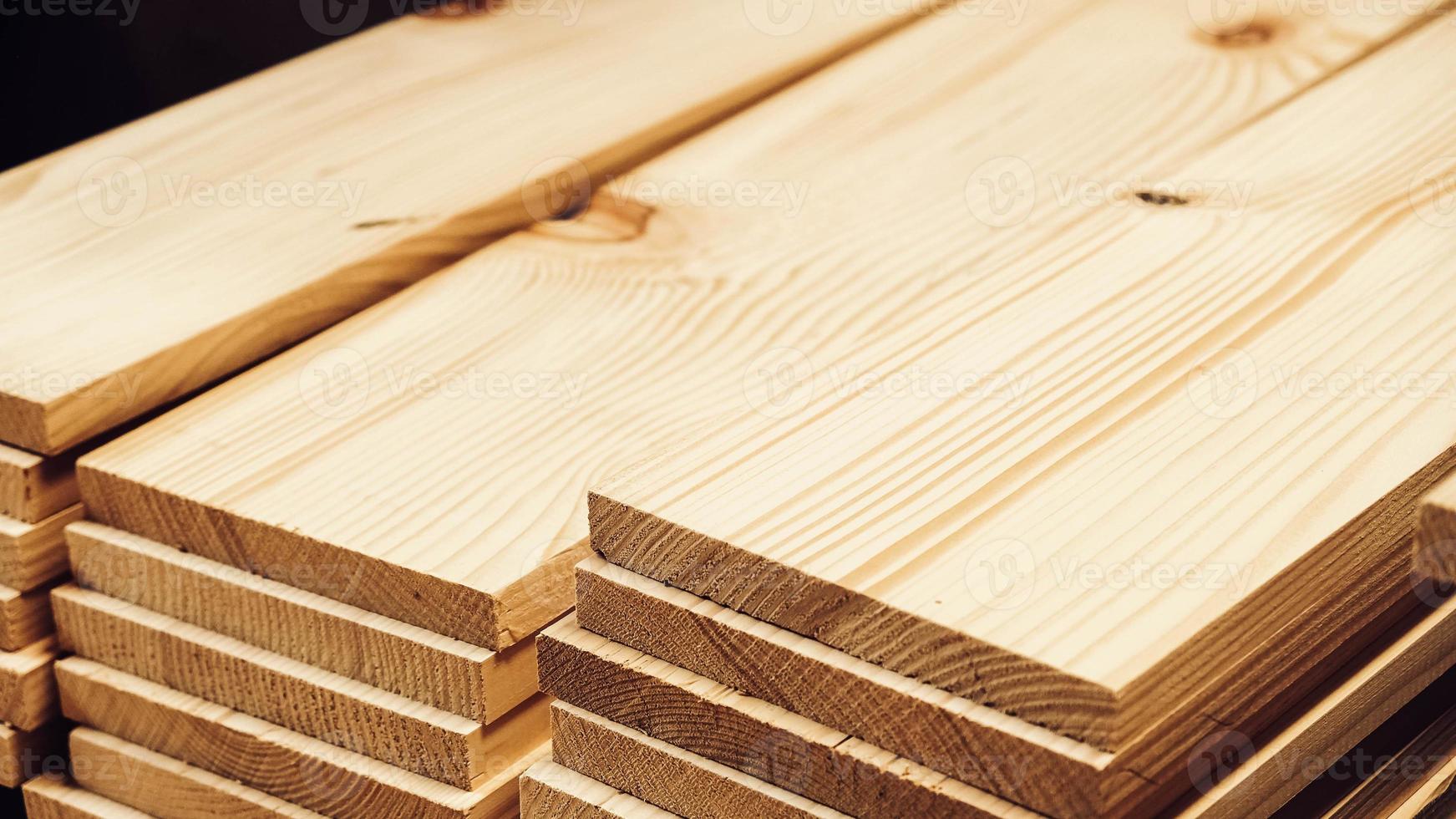 Stacked wooden carpentry boards from natural wood in a woodworking industry photo