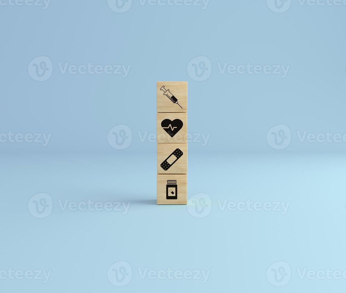 Wooden cube block tower with healthcare icon syringe, health, pills and band on blue studio background. photo