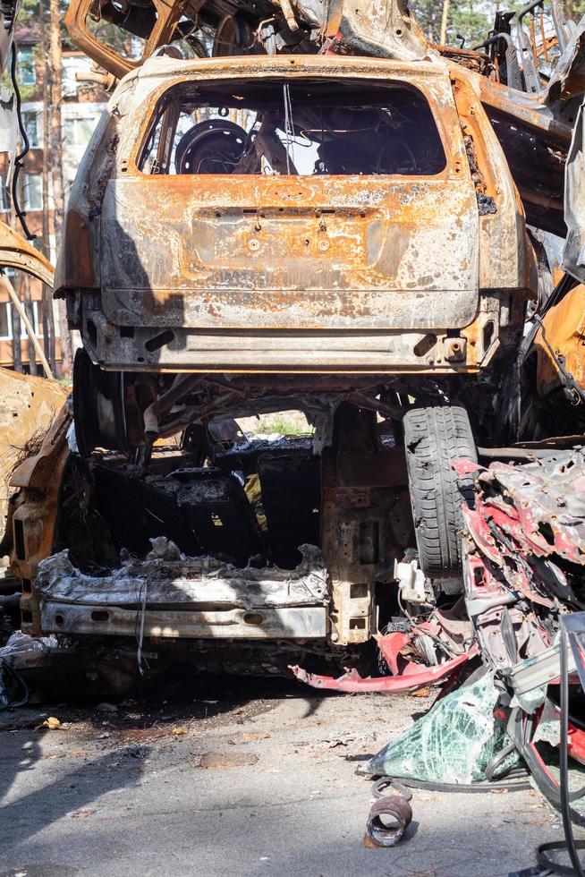 A lot of rusty burnt cars in Irpen, after being shot by the Russian military. Russia's war against Ukraine. Cemetery of destroyed cars of civilians. Ukraine, Irpen - May 12, 2022. photo