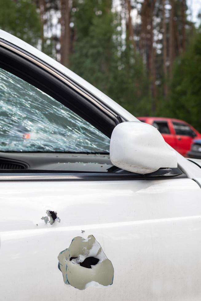 Car riddled with bullets. War of Russia against Ukraine. A car of civilians shot by the Russian military during the evacuation of women and children. Ukraine, Irpen - May 12, 2022. photo