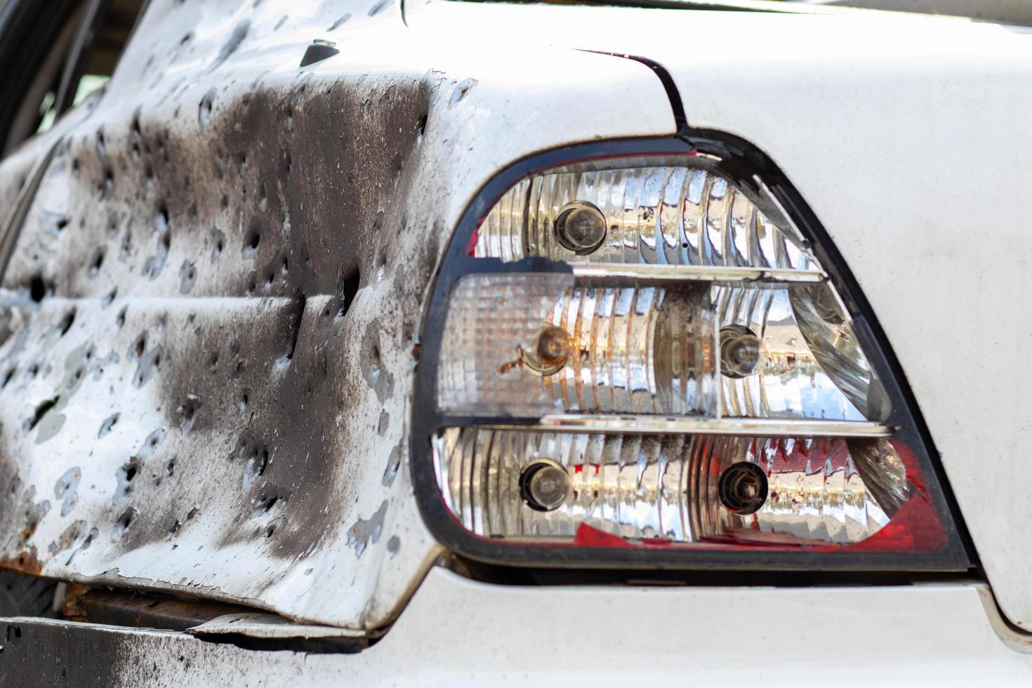 Shot, damaged cars during the war in Ukraine. The vehicle of civilians affected by the hands of the Russian military. Shrapnel and bullet holes in the body of the car. Ukraine, Irpen - May 12, 2022. photo