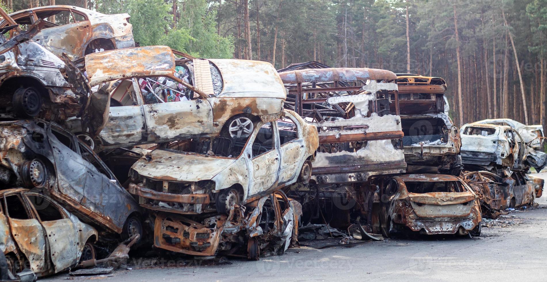 Rusty burnt cars destroyed by rocket explosions. War in Ukraine. Destroyed vehicles of civilians who were leaving were evacuated from the combat zone from Bucha and Irpin. Car graveyard. photo