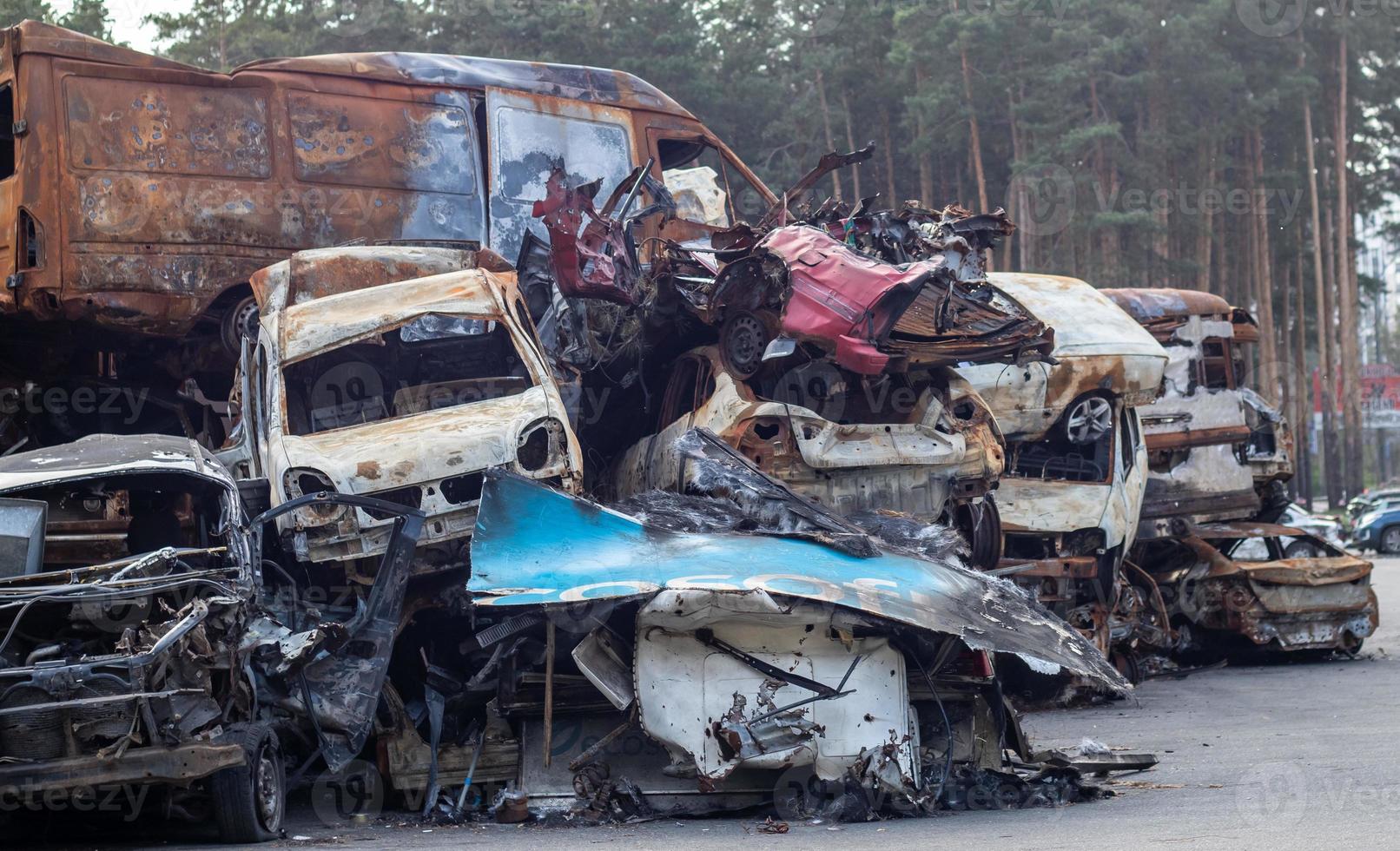 Rusty burnt cars destroyed by rocket explosions. War in Ukraine. Destroyed vehicles of civilians who were leaving were evacuated from the combat zone from Bucha and Irpin. Car graveyard. photo