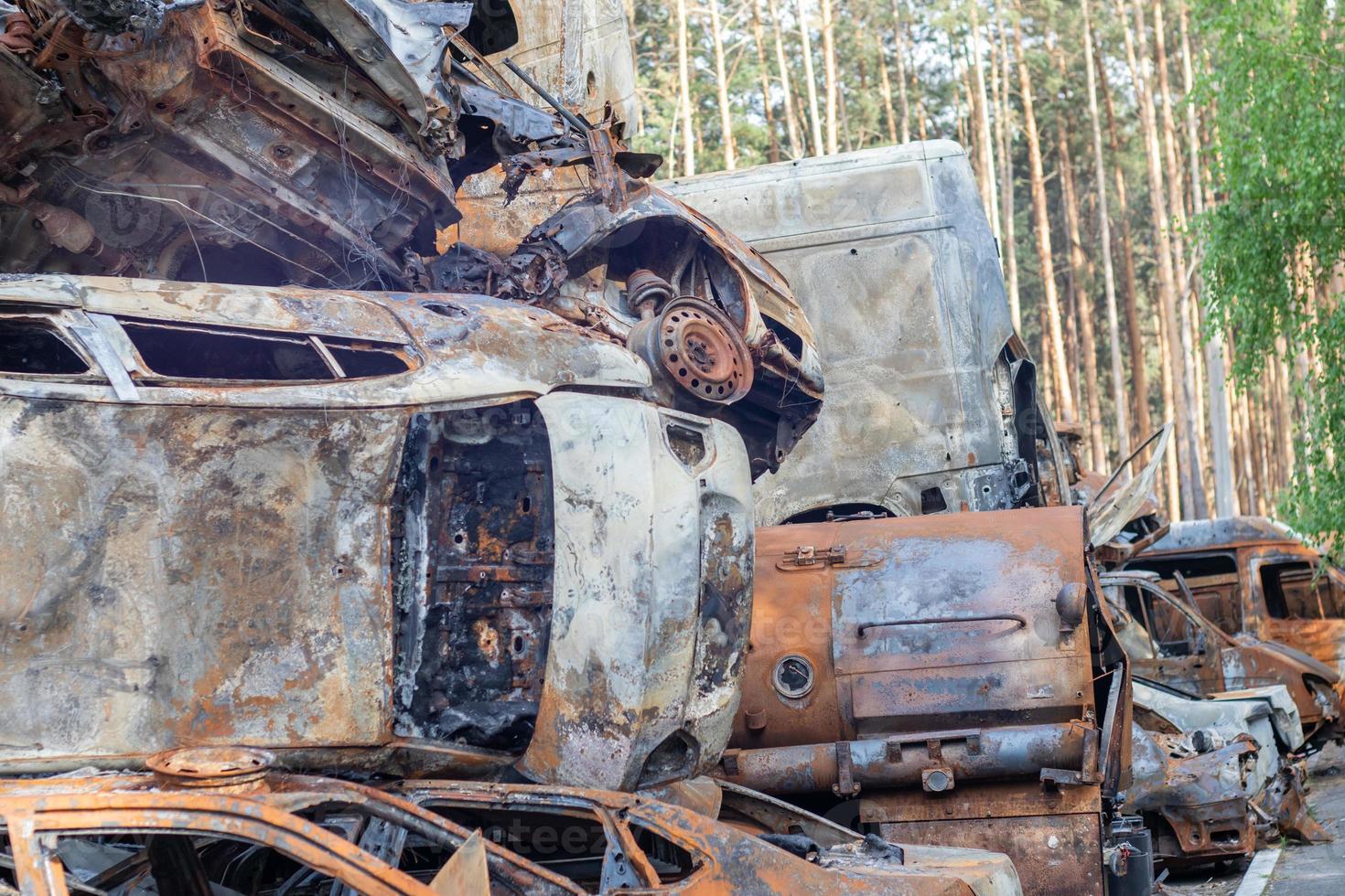 Rusty burnt cars destroyed by rocket explosions. War in Ukraine. Destroyed vehicles of civilians who were leaving were evacuated from the combat zone from Bucha and Irpin. Car graveyard. photo