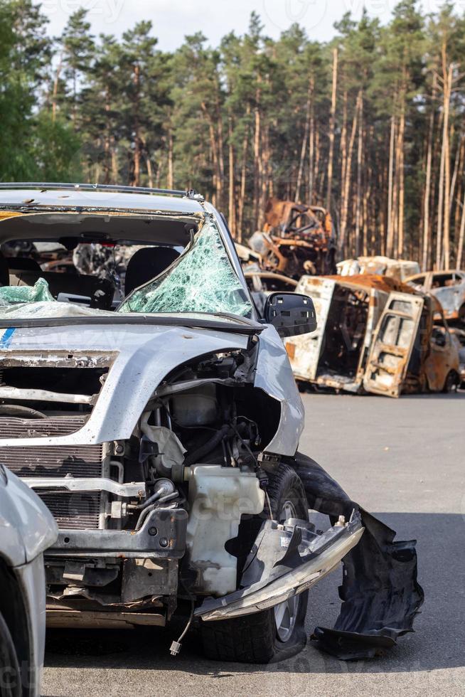 Dump of shot and burned civilian cars by Russian invaders in Ukraine. The remains of cars that were shot and destroyed by shell fragments. War of Russia against Ukraine. Car graveyard. photo