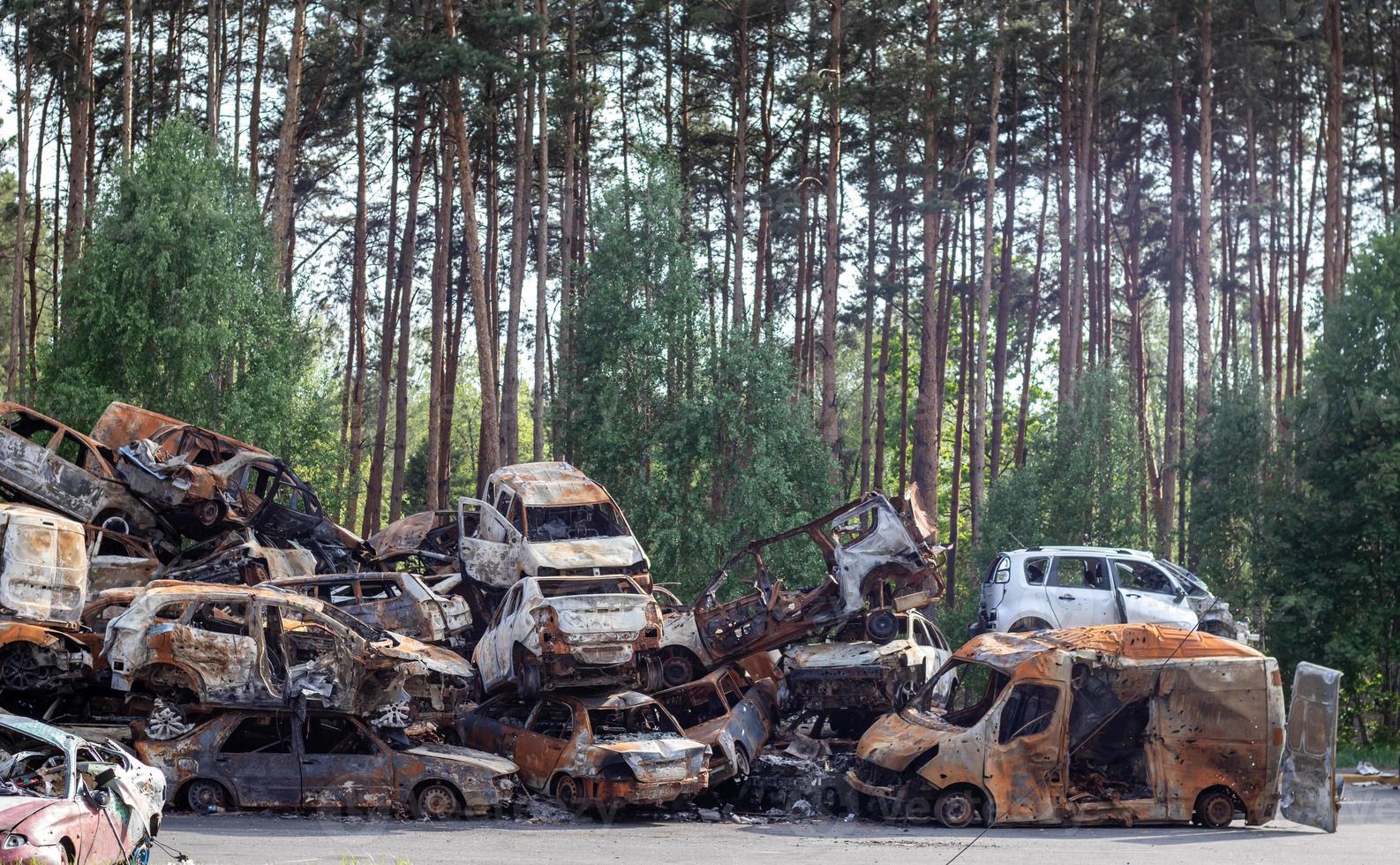 Rusty burnt cars destroyed by rocket explosions. War in Ukraine. Destroyed vehicles of civilians who were leaving were evacuated from the combat zone from Bucha and Irpin. Car graveyard. photo