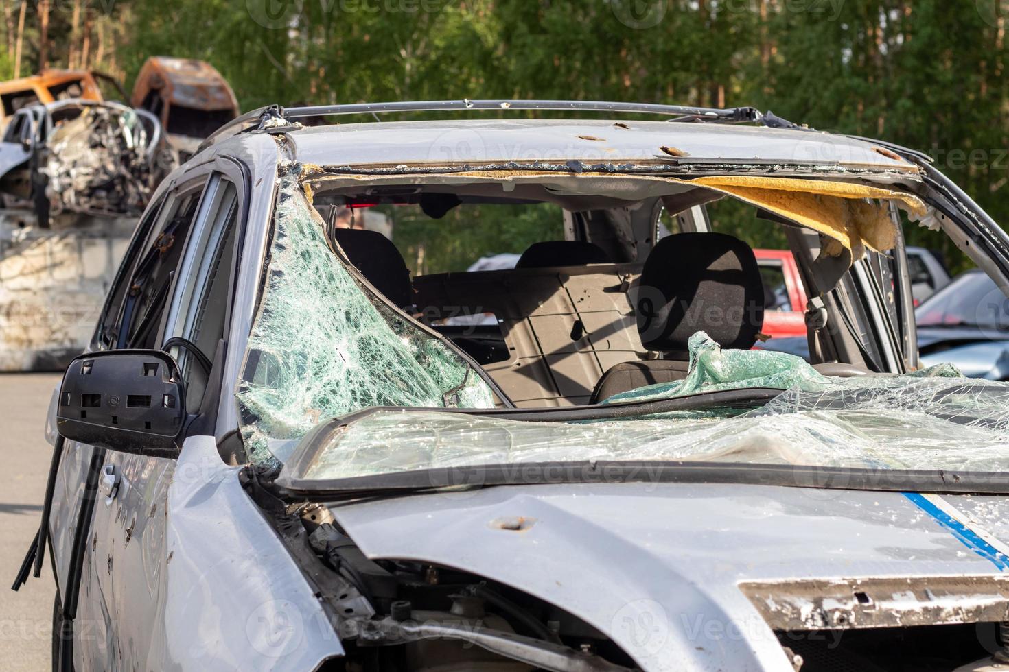 Dump of shot and burned civilian cars by Russian invaders in Ukraine. The remains of cars that were shot and destroyed by shell fragments. War of Russia against Ukraine. Car graveyard. photo