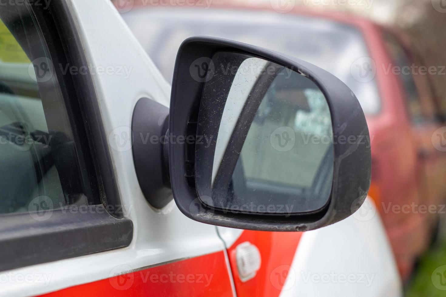 Side right black plastic rearview mirror on a white car. Exterior side view mirror on the passenger side, electrically adjustable and heated. photo