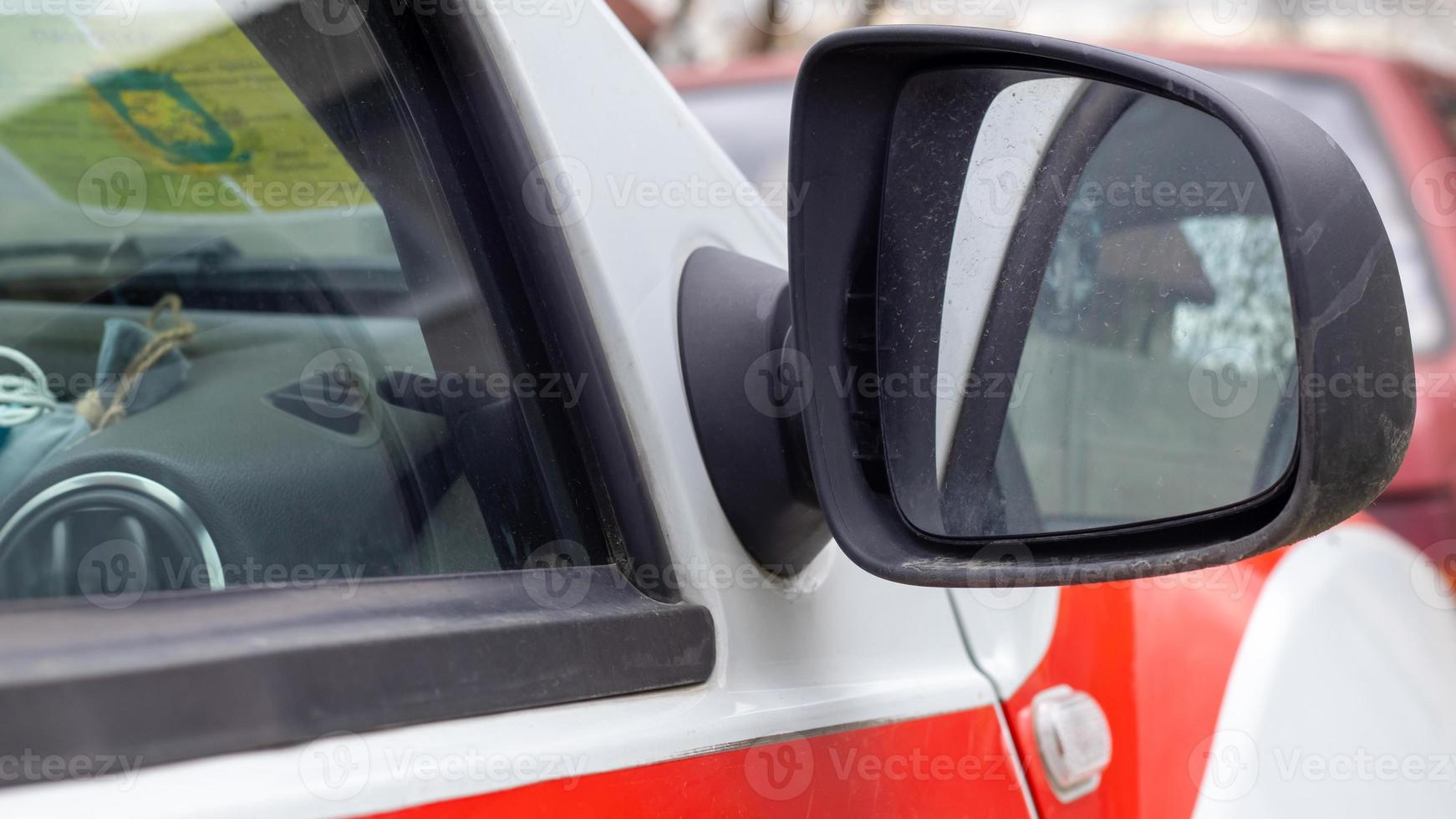 Side right black plastic rearview mirror on a white car. Exterior side view mirror on the passenger side, electrically adjustable and heated. photo