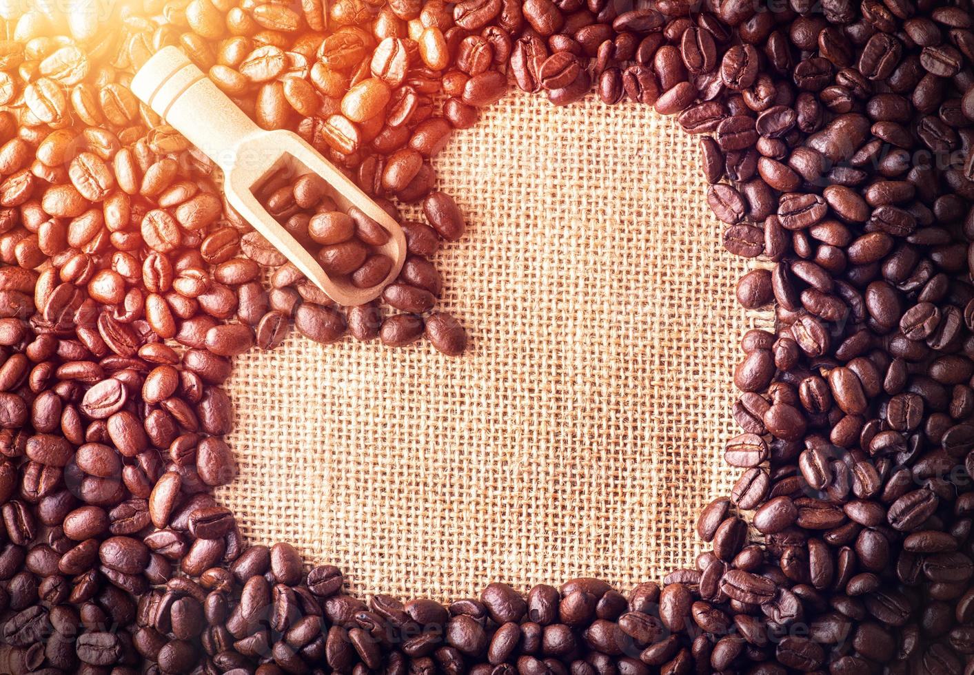 cucharada de granos de café dispuestos en forma de corazón en el fondo de la bolsa foto