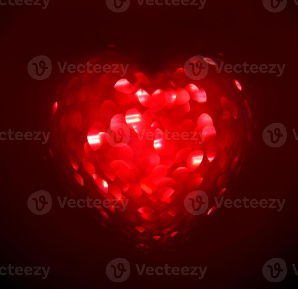 Red Blur heart shape of ligth bokeh on a black background photo