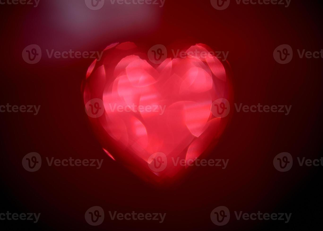 Red Blur heart shape of ligth bokeh on a black background photo
