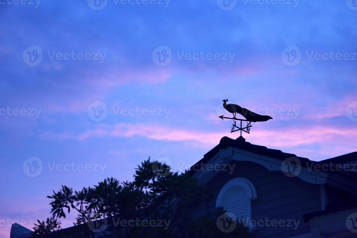 weather vane at sunrise with bright colors in clouds photo