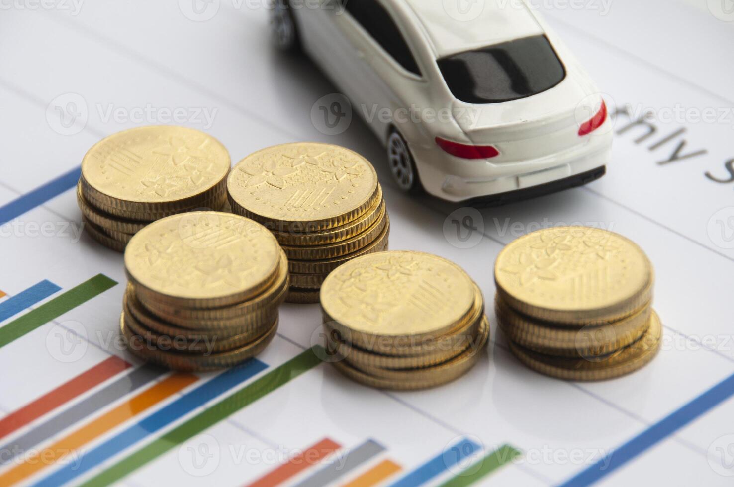 Business concept. Analysis of data through bar chart with gold coins and toy car background. Conceptual photo