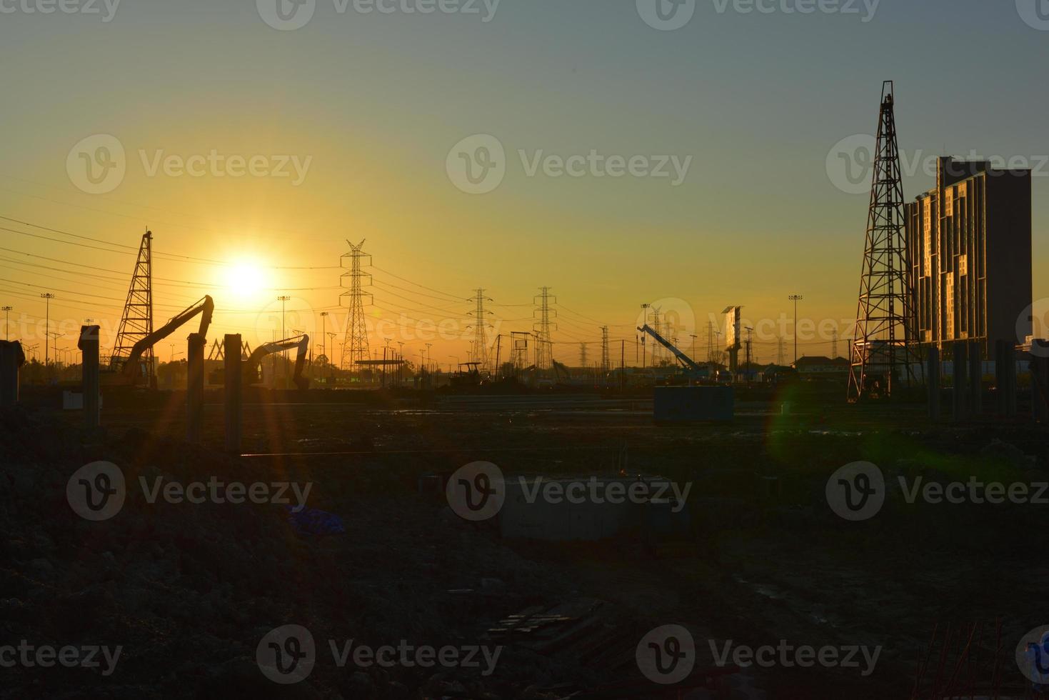 sitio de construcción y poste eléctrico con cielo de amanecer foto