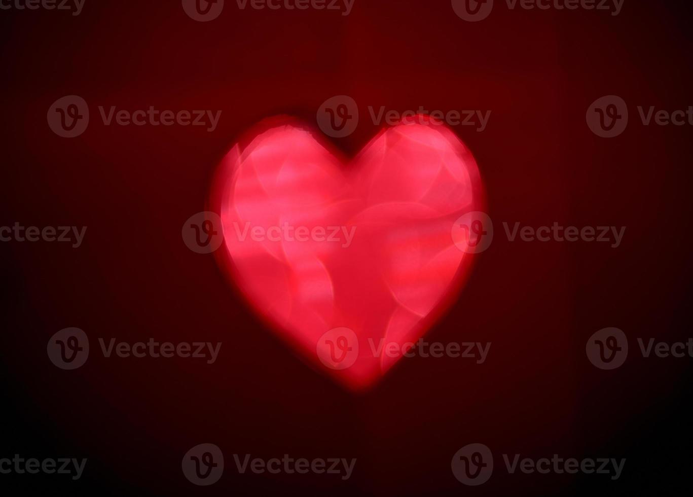 Red Blur heart shape of ligth bokeh on a black background photo