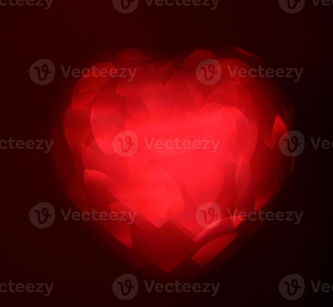 Red Blur heart shape of ligth bokeh on a black background photo