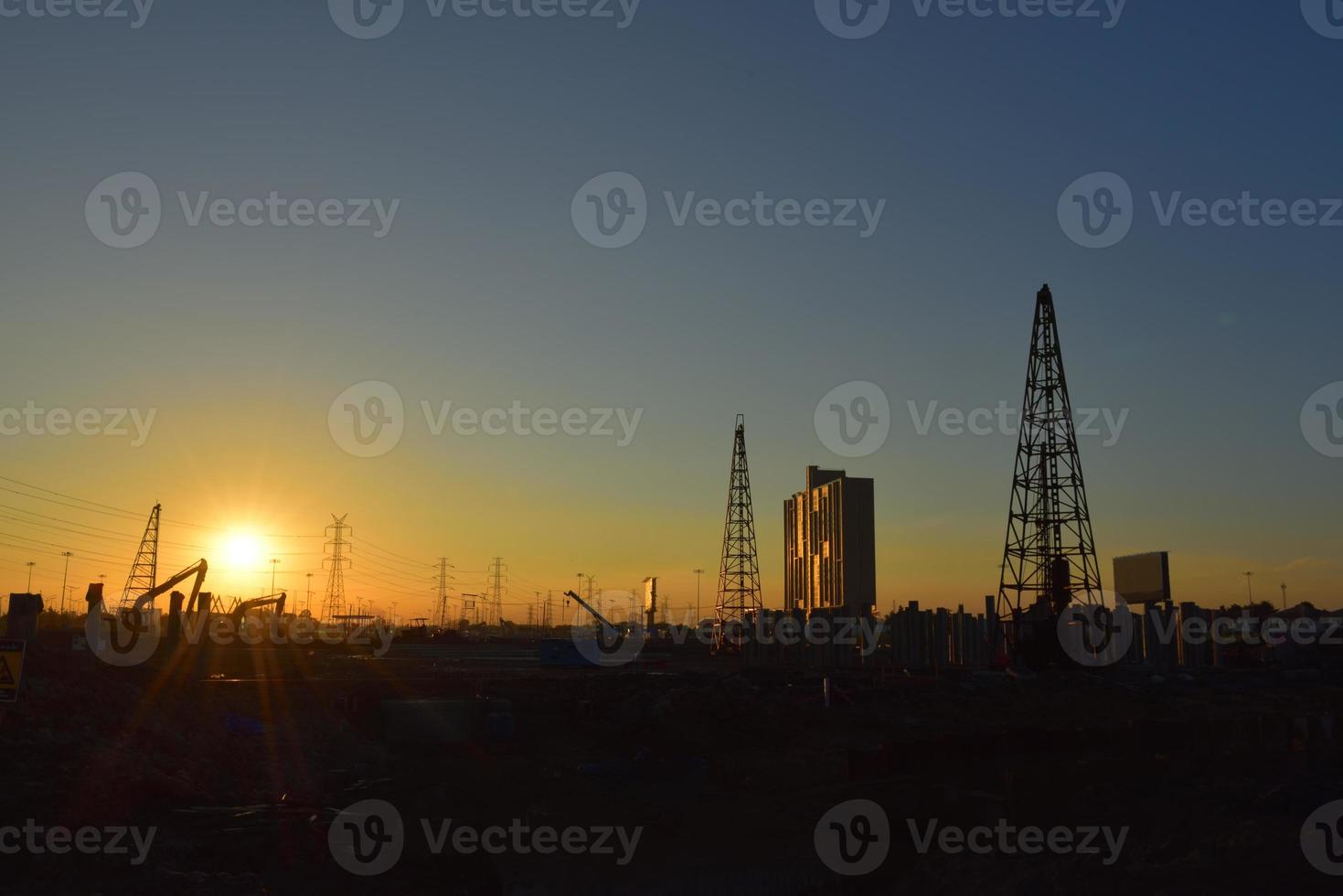 sitio de construcción y poste eléctrico con cielo de amanecer foto