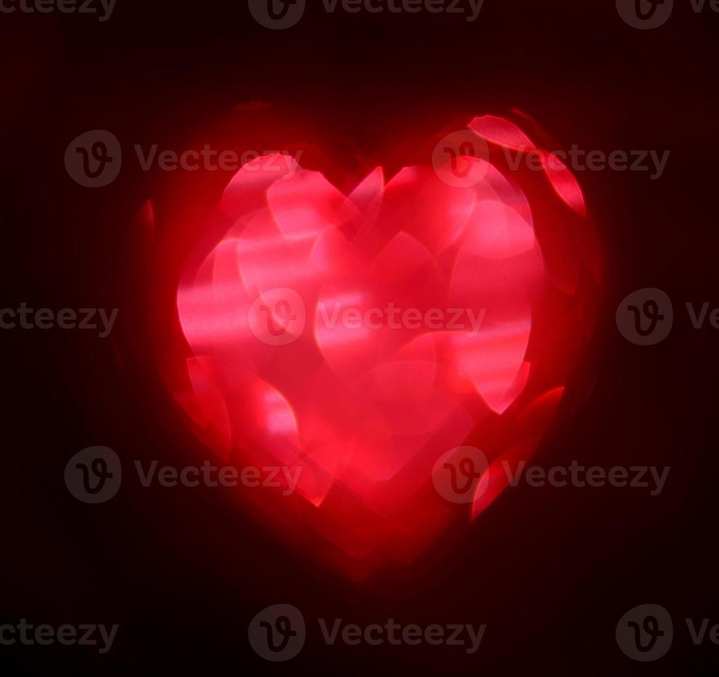 Red Blur heart shape of ligth bokeh on a black background photo