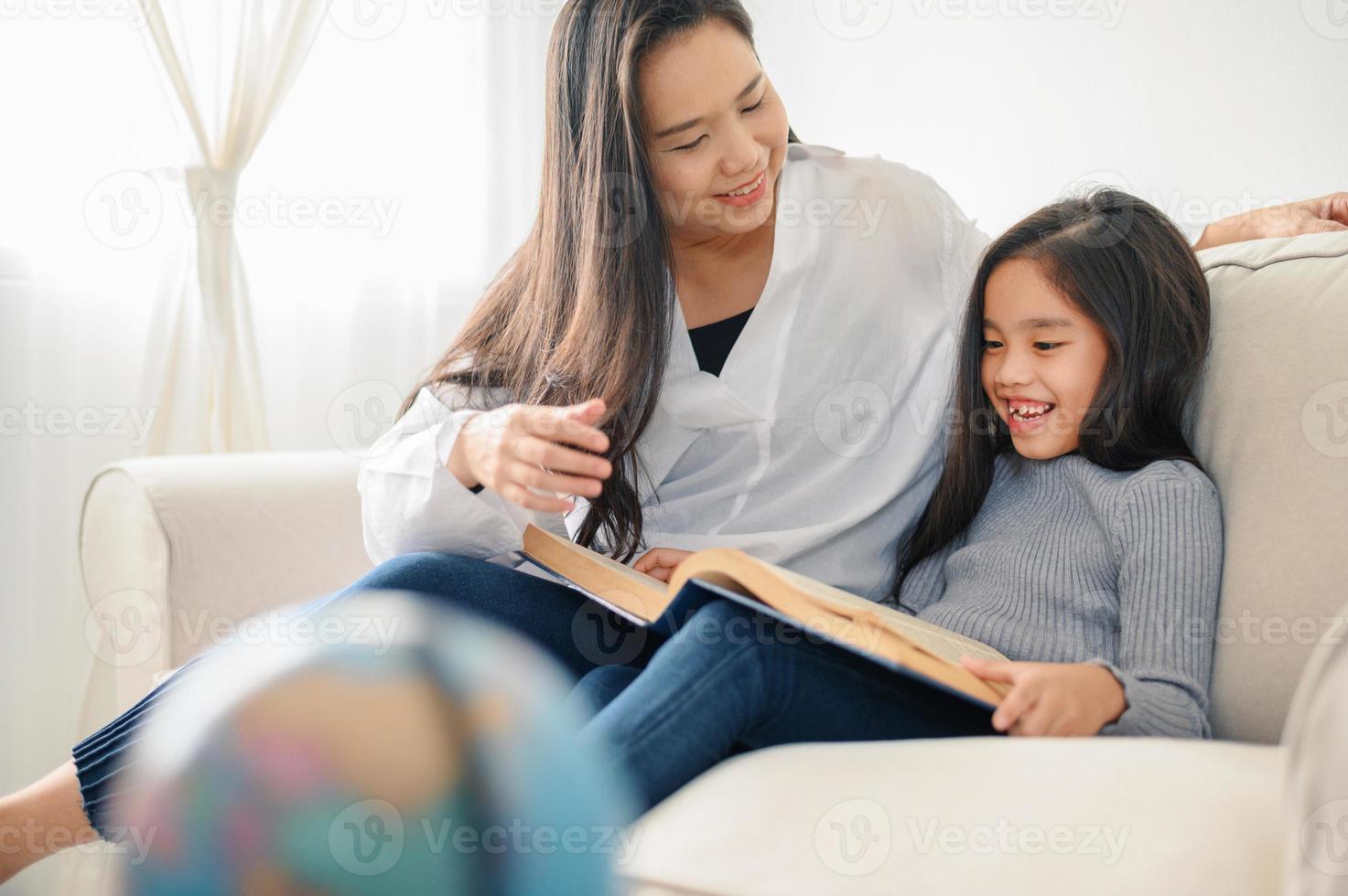 mother and child daughter doing homework  and reading at home photo