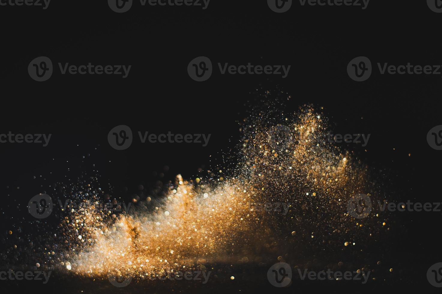 Gold glitter texture on a black background. Golden grainy abstract texture on a black background. Design element. photo