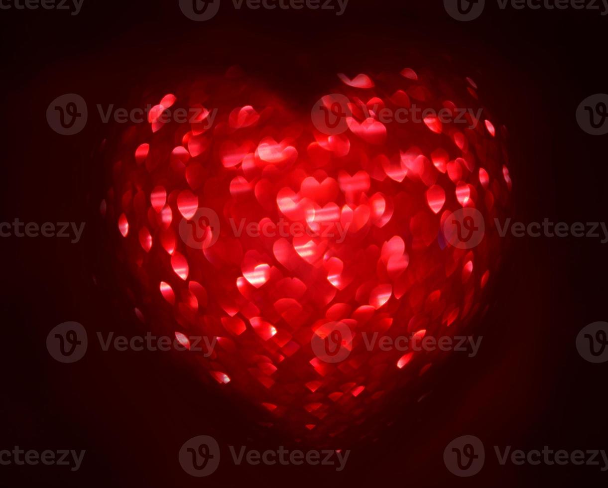 Red Blur heart shape of ligth bokeh on a black background photo