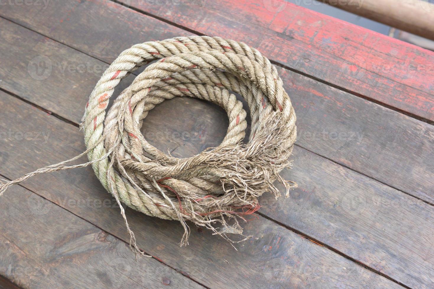 The rope rests on a wooden background photo