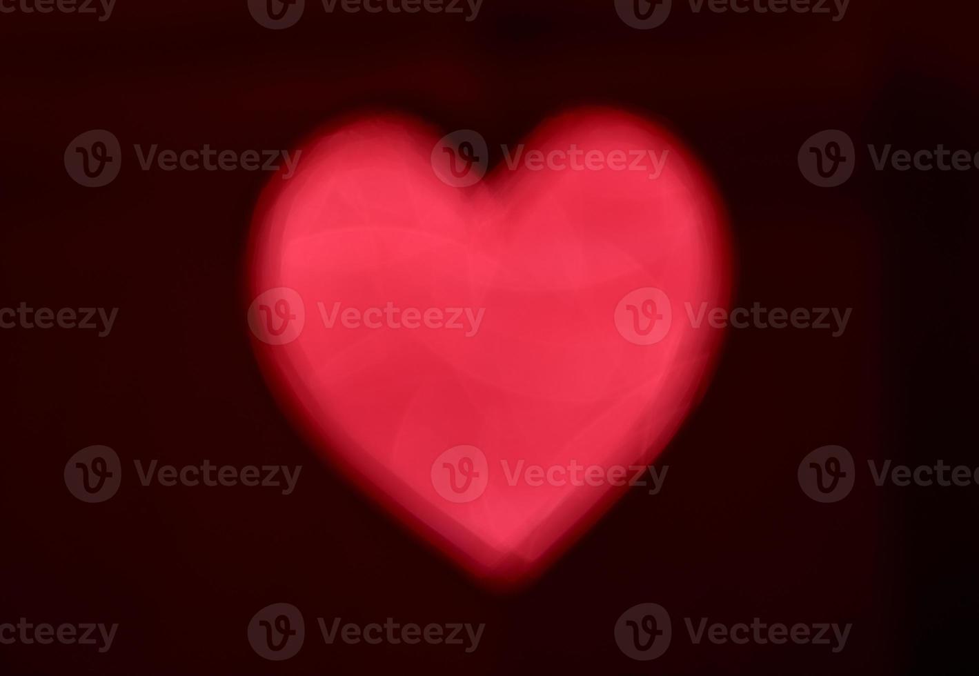 Red Blur heart shape of ligth bokeh on a black background photo