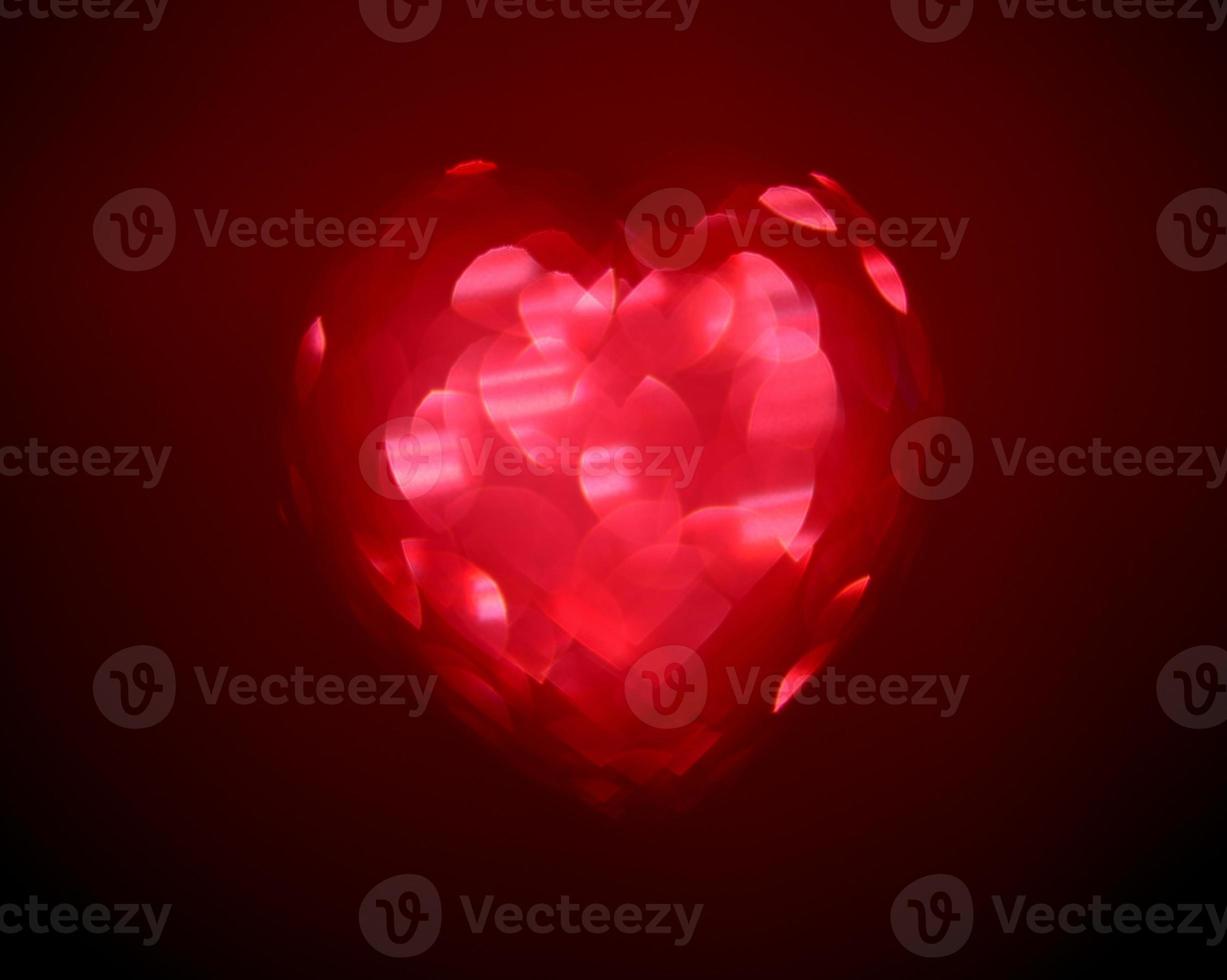 Red Blur heart shape of ligth bokeh on a black background photo