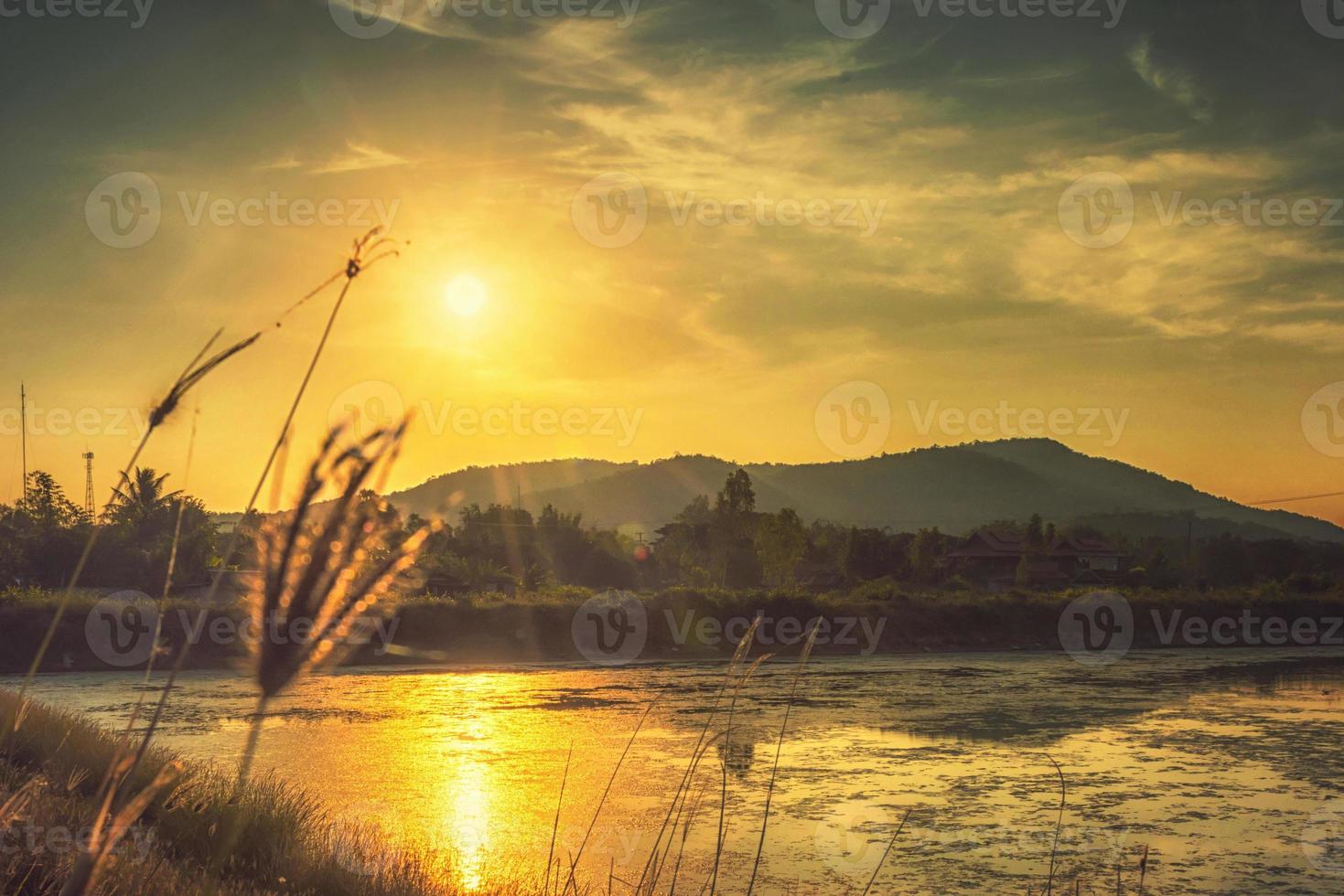Nature with mountains rivers grass the light of the sunset photo