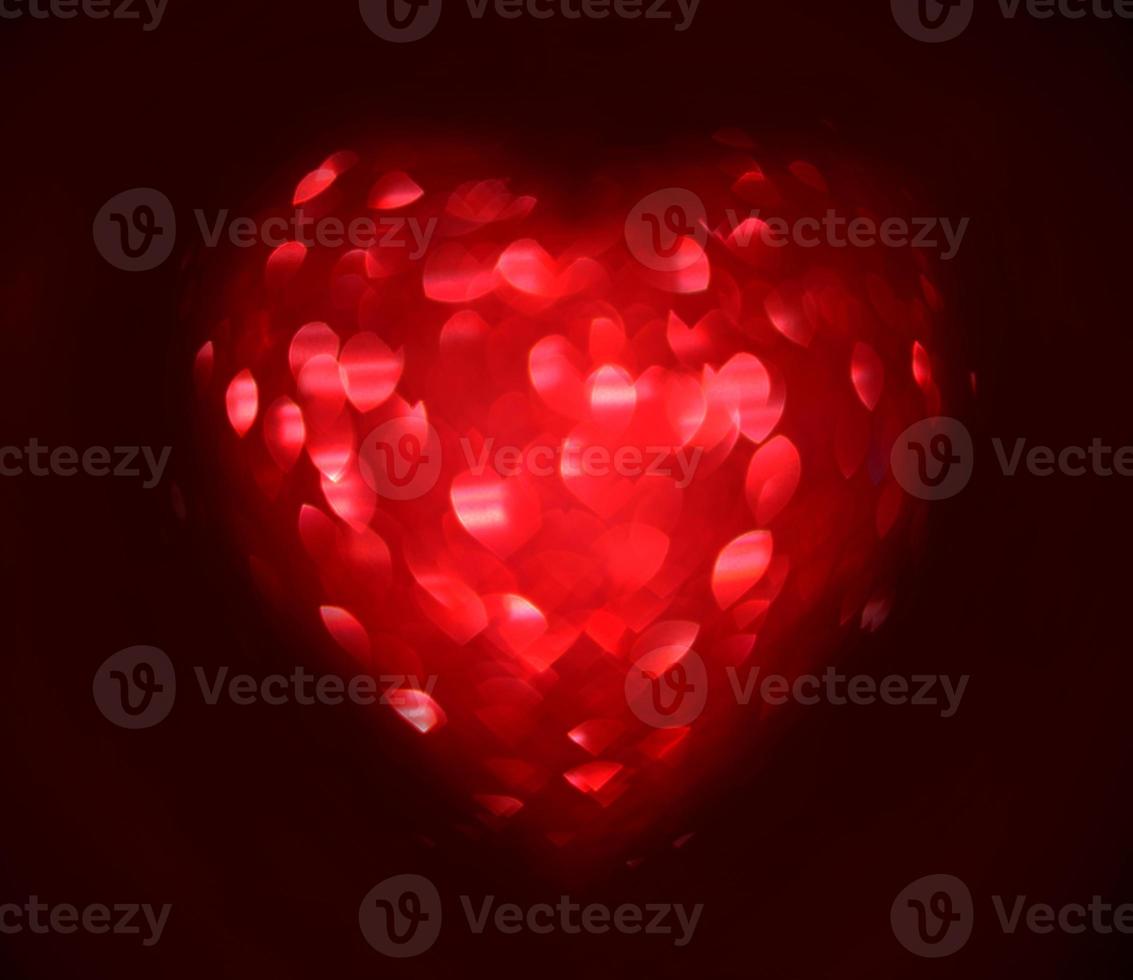 Red Blur heart shape of ligth bokeh on a black background photo