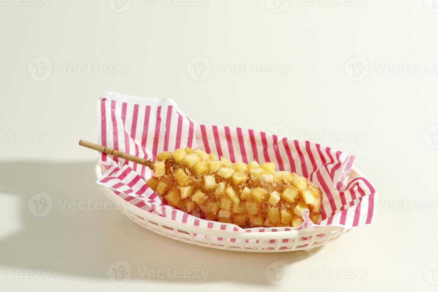 Delicious Crunchy Korean Style Chunky Potato Corn Dogs with Batter and Fried Potatoes. Isolated on Cream Background photo
