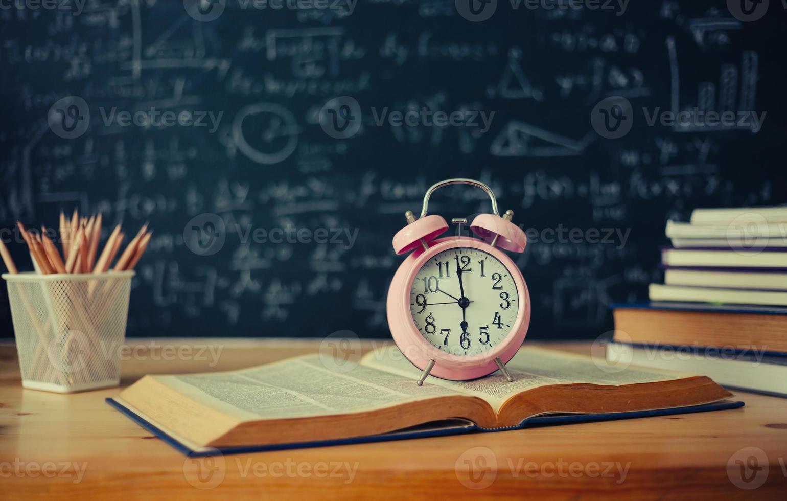School books on desk formulas and Physics inscription on the blackboard , education concept photo
