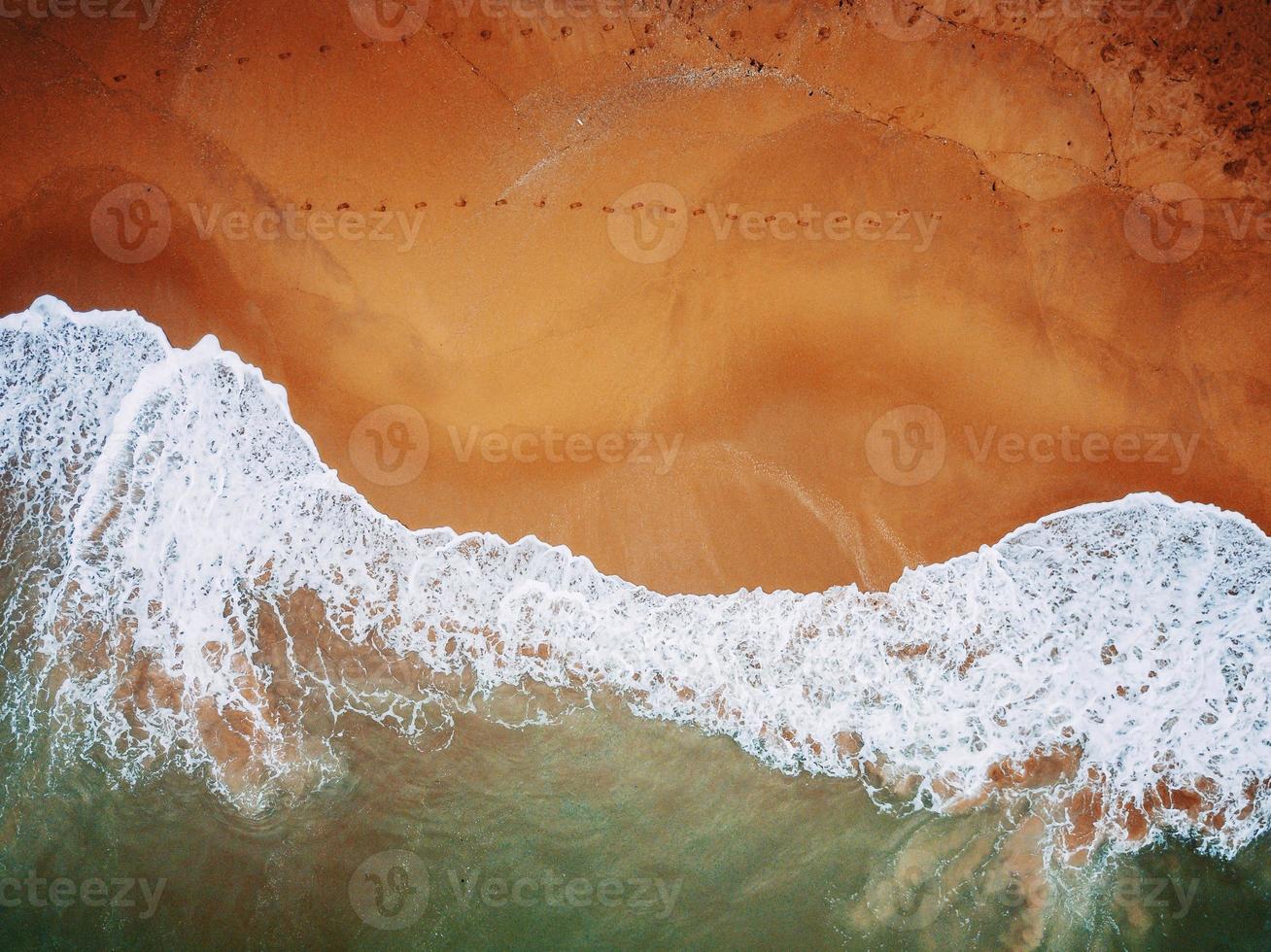 Beach on aerial drone top view with ocean waves reaching shore. photo