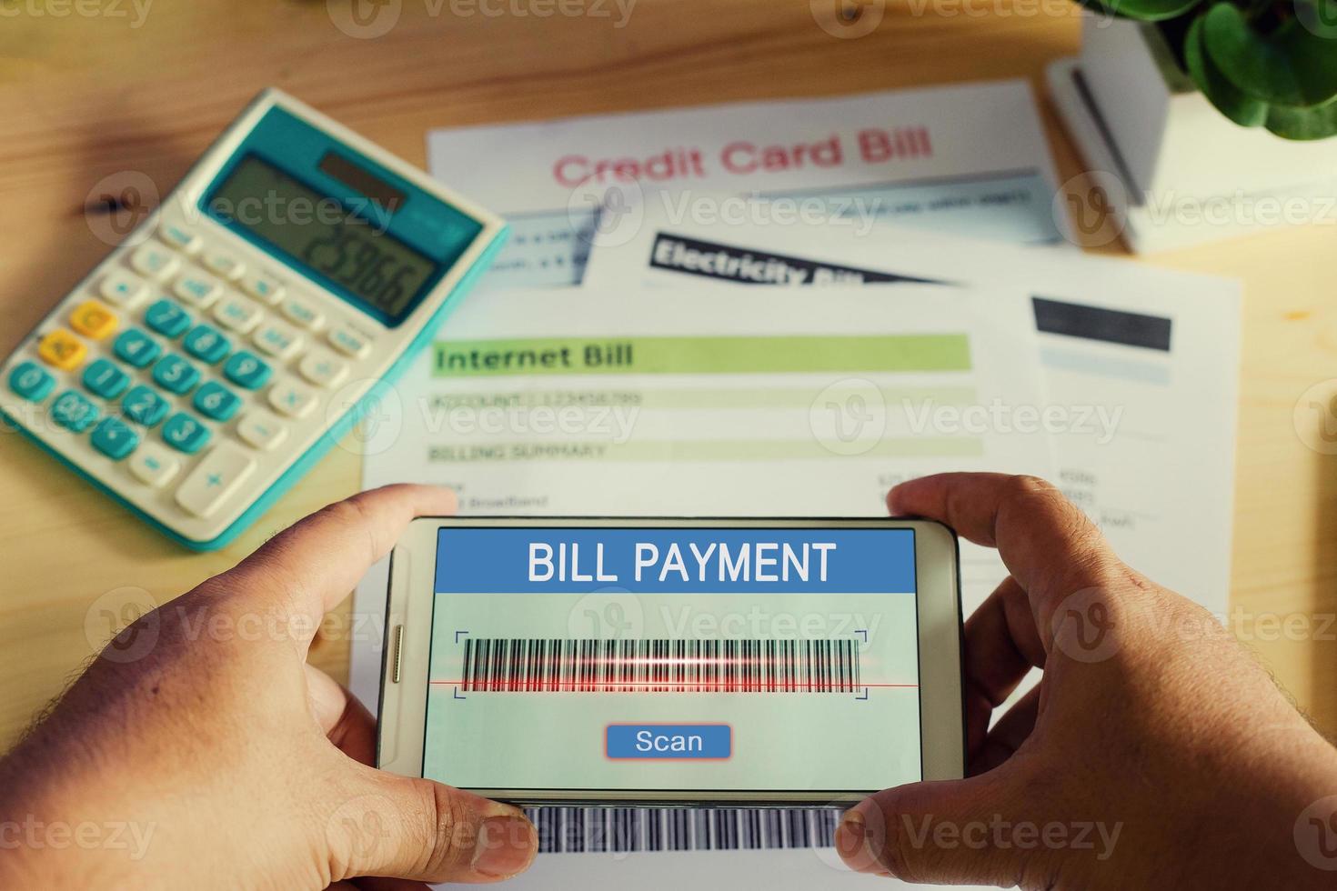 Mobile scan barcode bill payment concept.Man hands using mobile phone scan bills photo