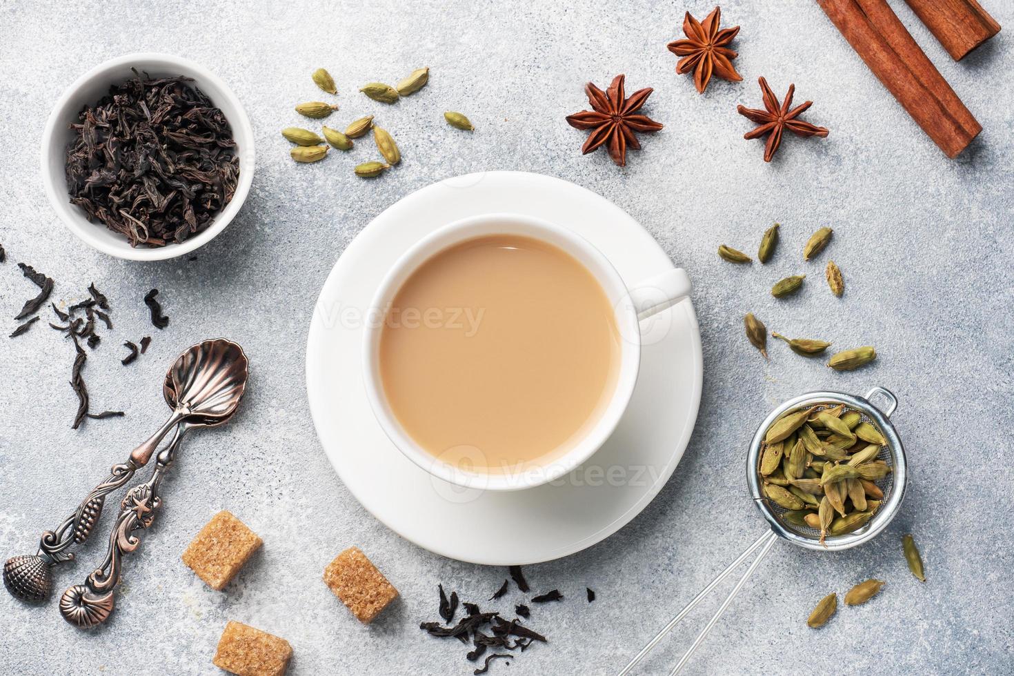 Indian drink masala tea with milk and spices. Cardamom sticks cinnamon star anise cane sugar. photo