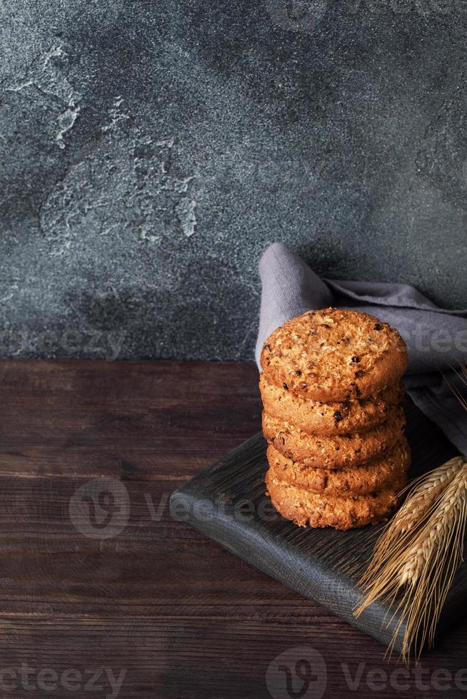 Homemade cookies with cereals and seeds. Oatmeal crackers on a wooden background. Copy space. photo