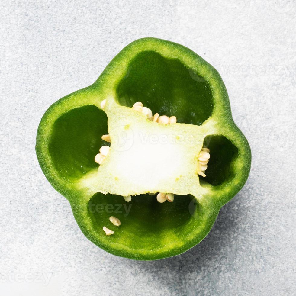 Fresh sweet green pepper in section on a grey concrete background. Copy space. photo