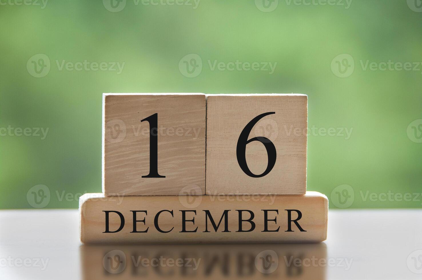16 de diciembre texto sobre bloques de madera con fondo de naturaleza borrosa. concepto de calendario foto