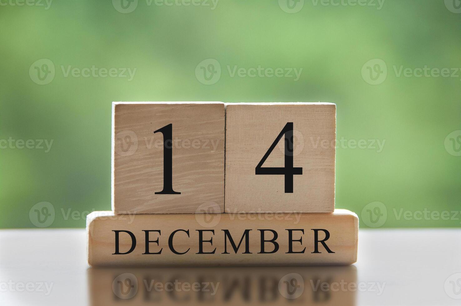 December 14 text on wooden blocks with blurred nature background. Calendar concept photo