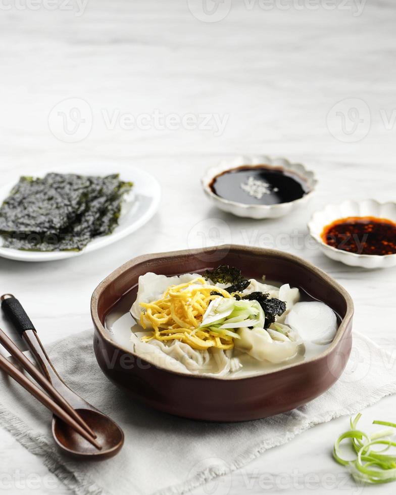 comida tradicional coreana sopa de pastel de arroz en rodajas, tteok y sopa de bola de mandu foto