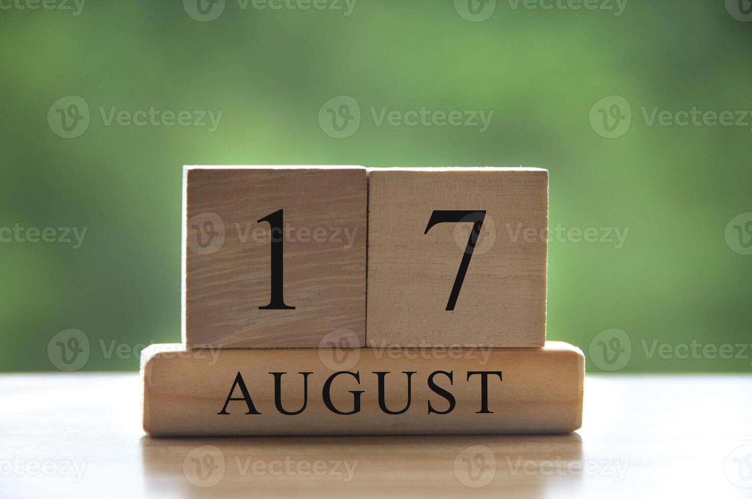17 de agosto texto de fecha de calendario en bloques de madera con parque de fondo borroso. copie el espacio y el concepto de calendario foto