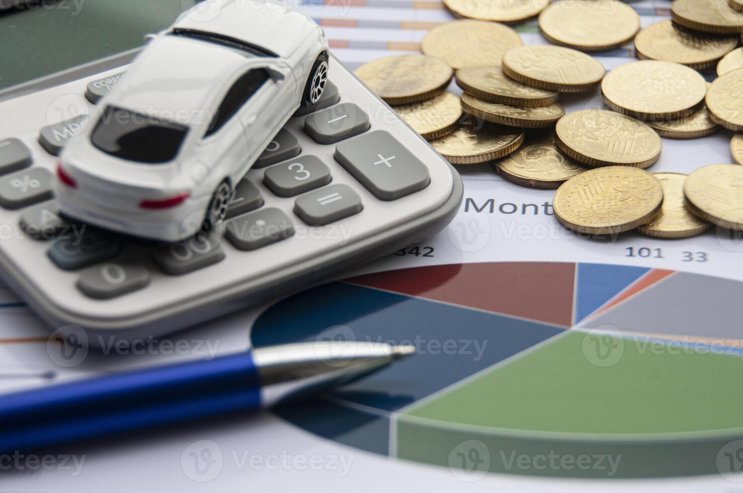 Analysis of data, chart and graphs with isolated calculator, gold coins and toy car. Business finances concept photo