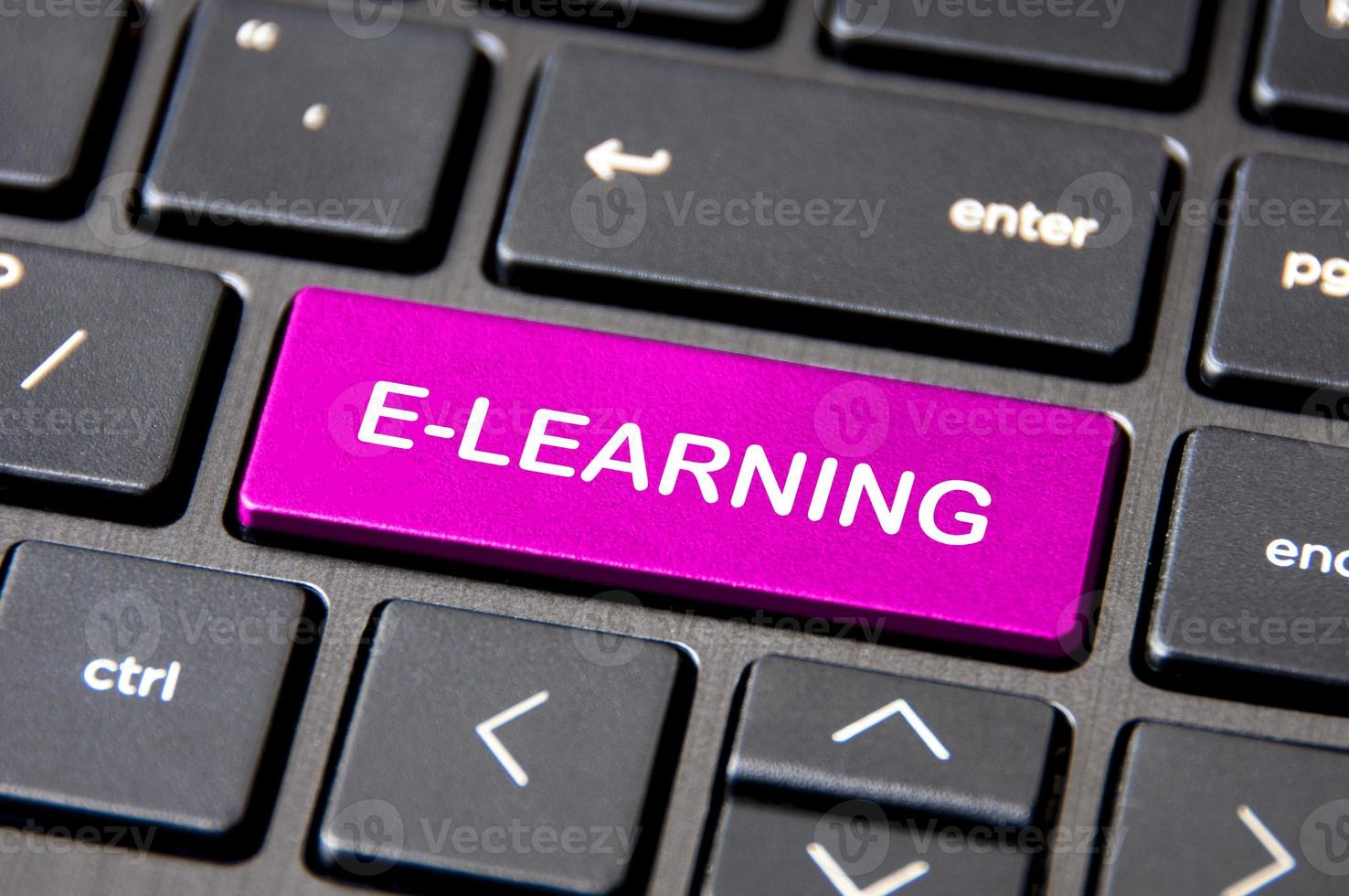 E-learning and online concept - Laptop keyboard with pink E-Learning button. photo