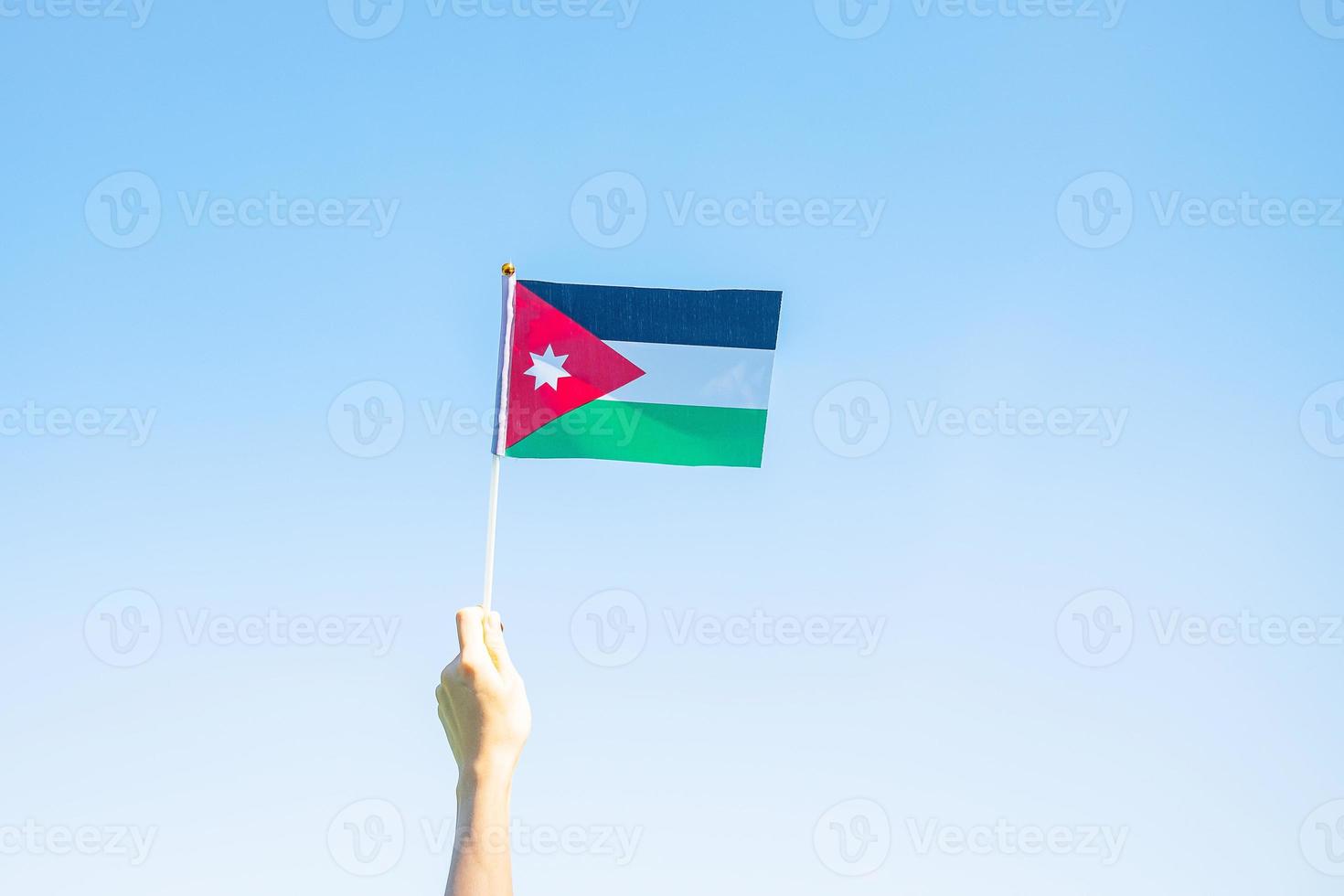 hand holding Jordan flag on nature background. Jordan Independence day and happy celebration concepts photo