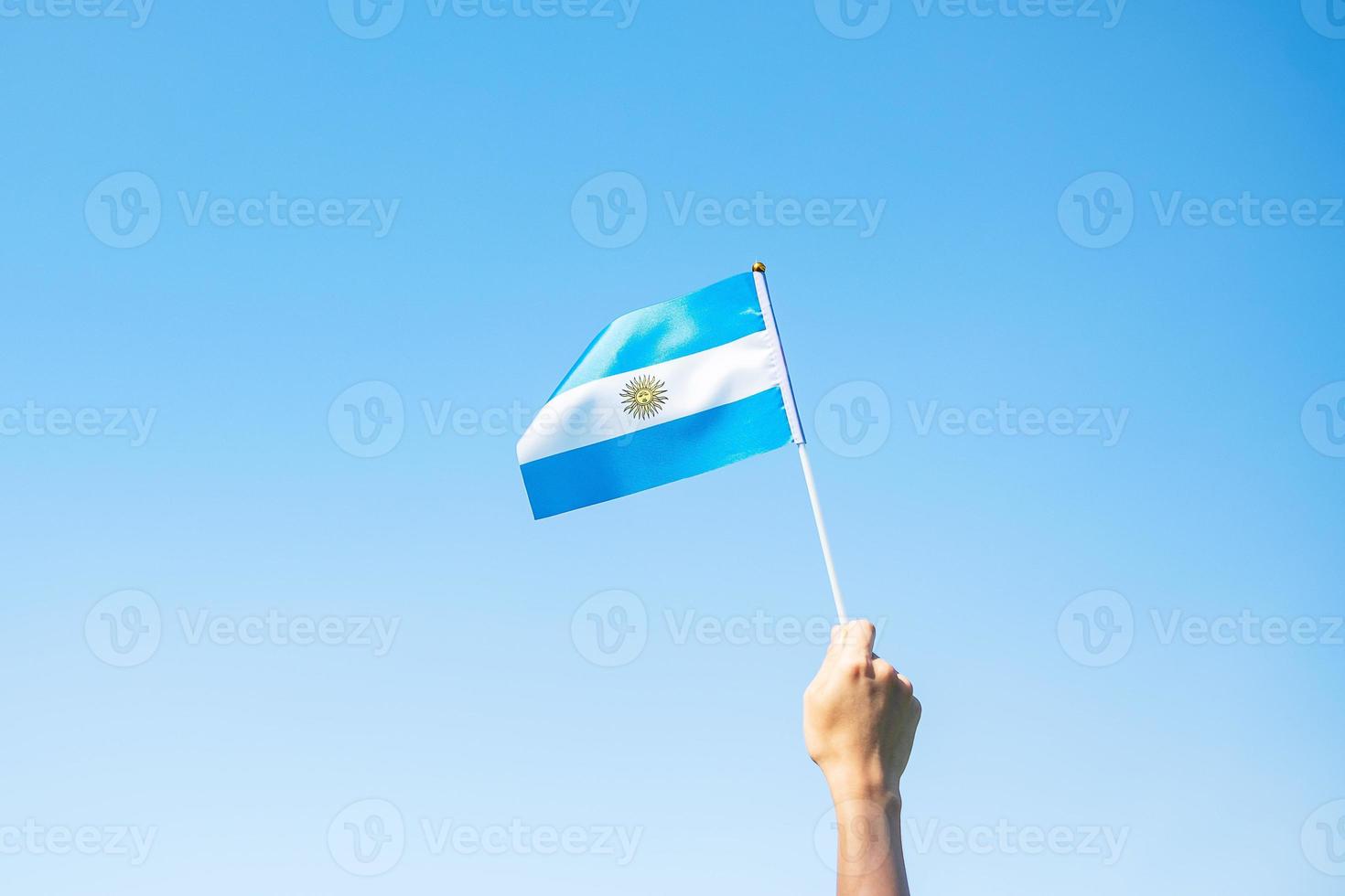hand holding Argentina flag on nature background. 9th July of Independence day, 25th May of Revolution day and happy celebration concepts photo