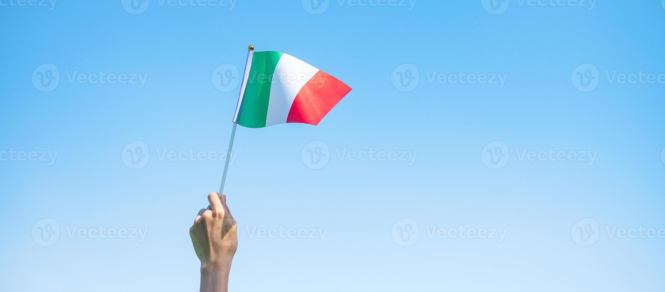 hand holding Italy flag on nature background. National Day, Republic Day, Festa della Repubblica and happy celebration concepts photo