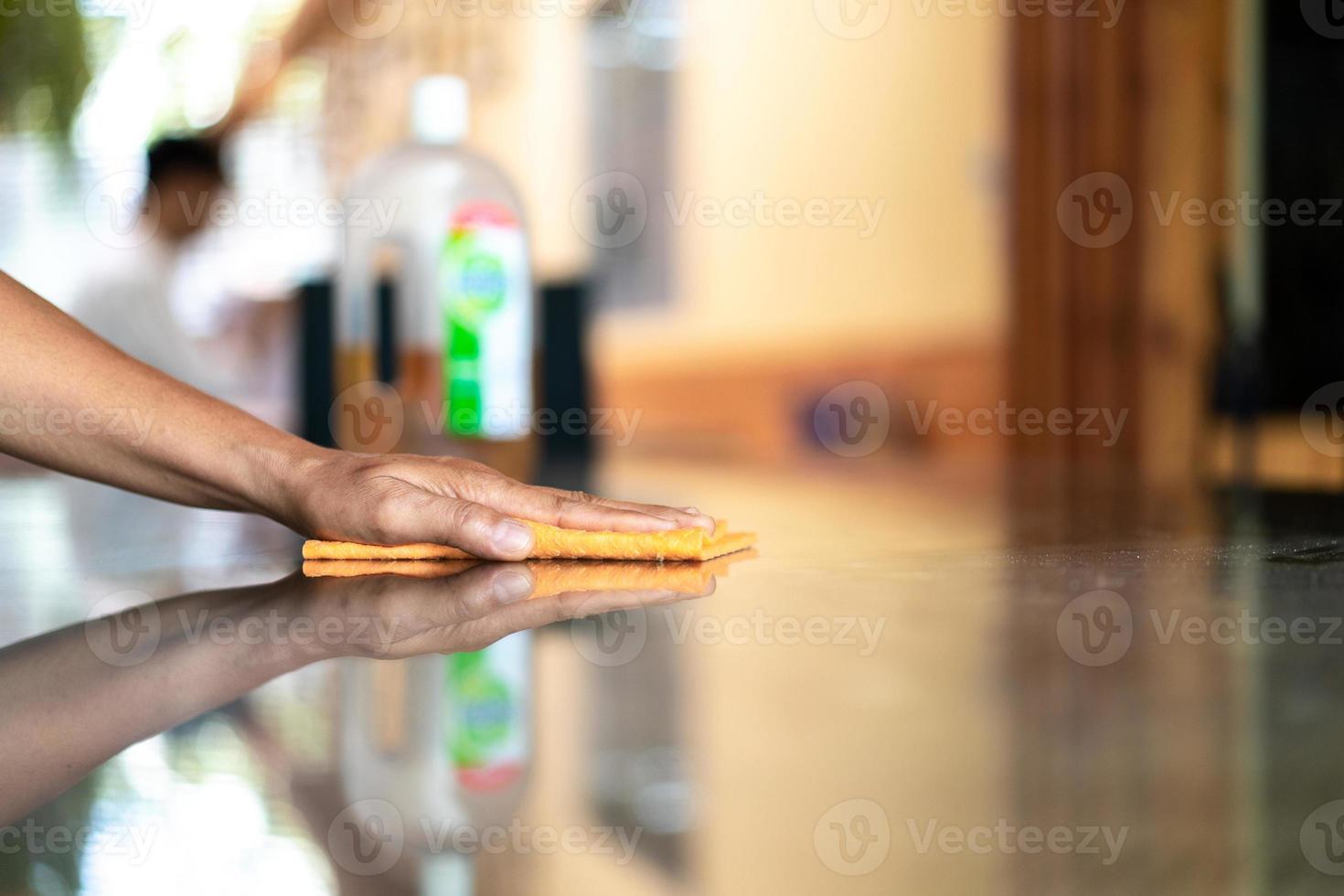 Asain maid worker is cleaning table with anti coronavirus cleanser in foggy before use. photo