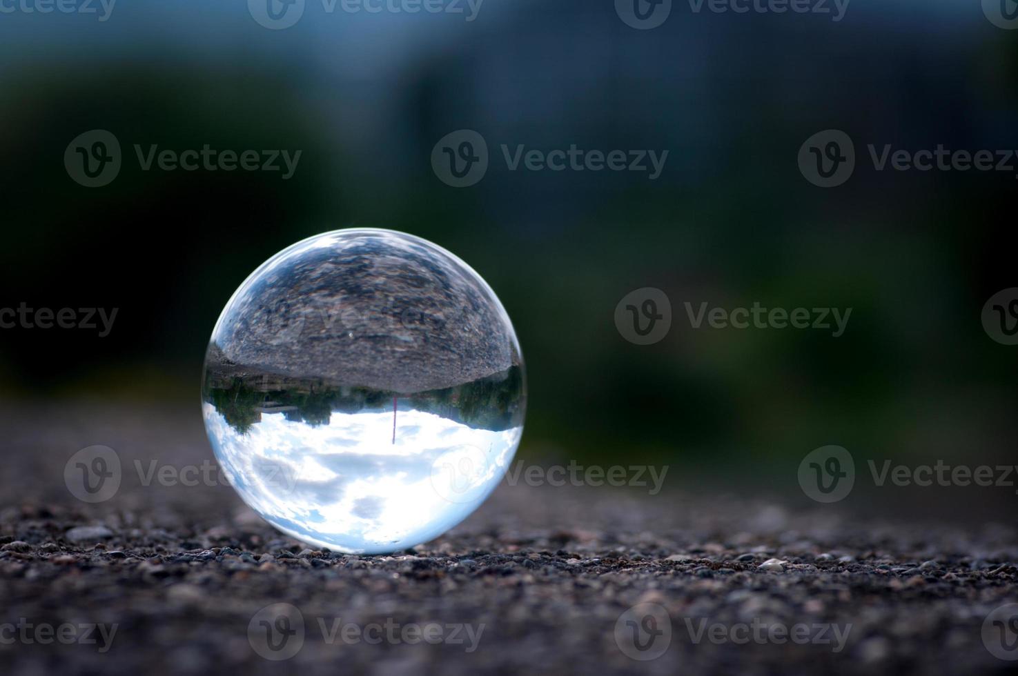 A lens ball with inverted landscape view. Close up image of a glass ball. photo